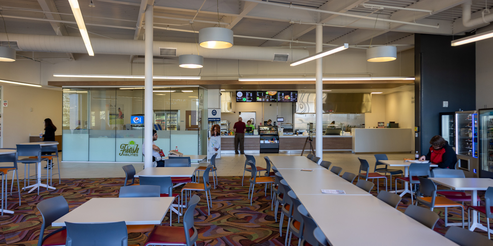 Freshabilites restaurant; tables with chairs in rows in front of the freshabilities kitchen.