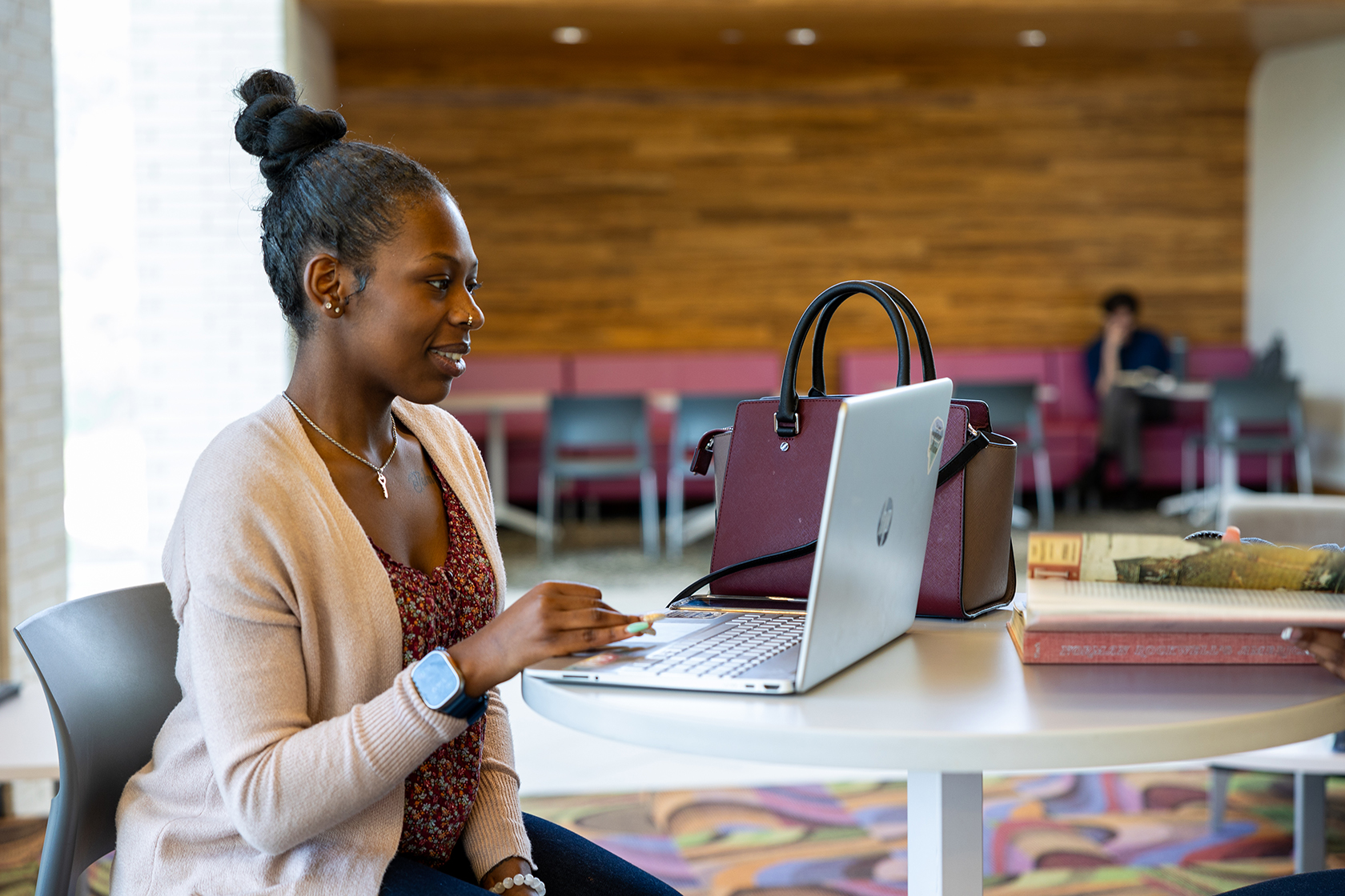 Student sits at table and works on laptop.