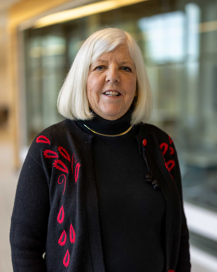 Peggy Noonan wearing a black shirt and black cardigan with red embroidery. 