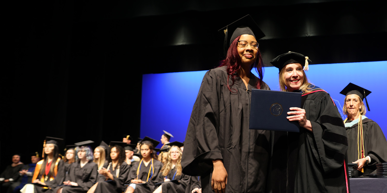 Dr. Blondin handing graduate their diploma