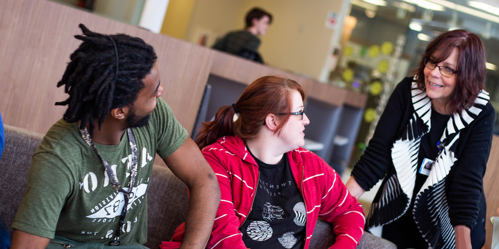 Trio students speaking with staff member.