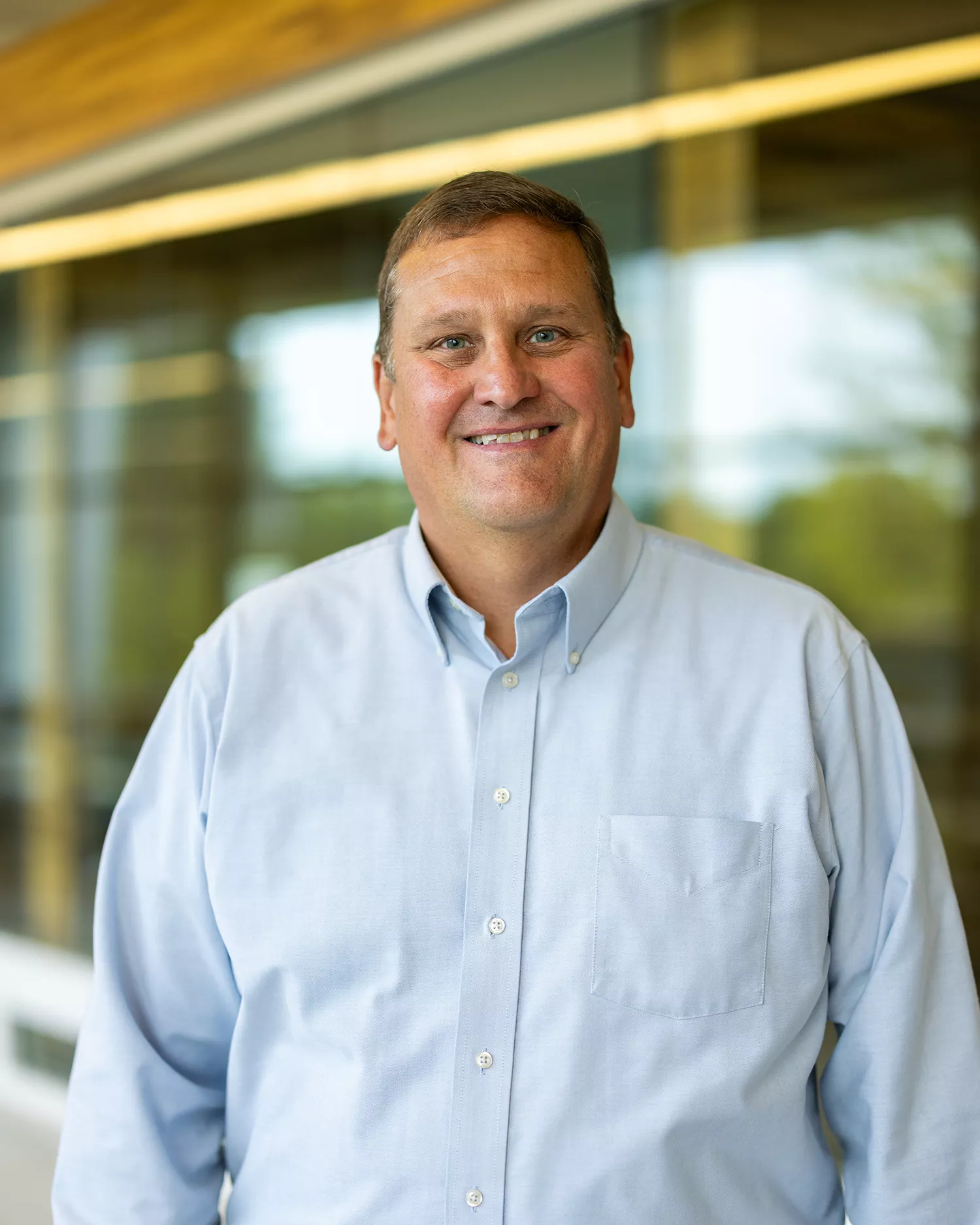 Smiling white male in light blue button down shirt 