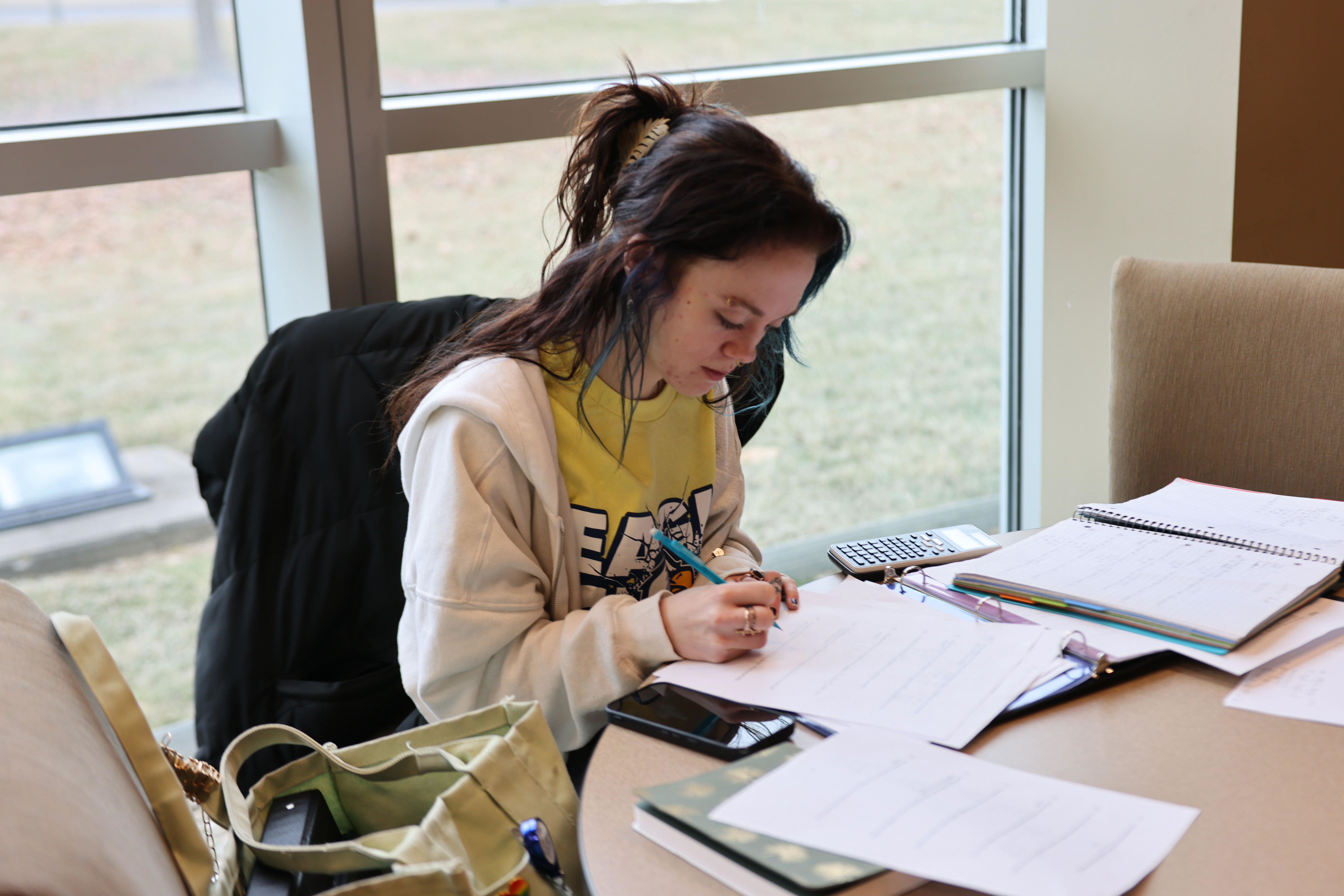 Student sitting at table completing handout