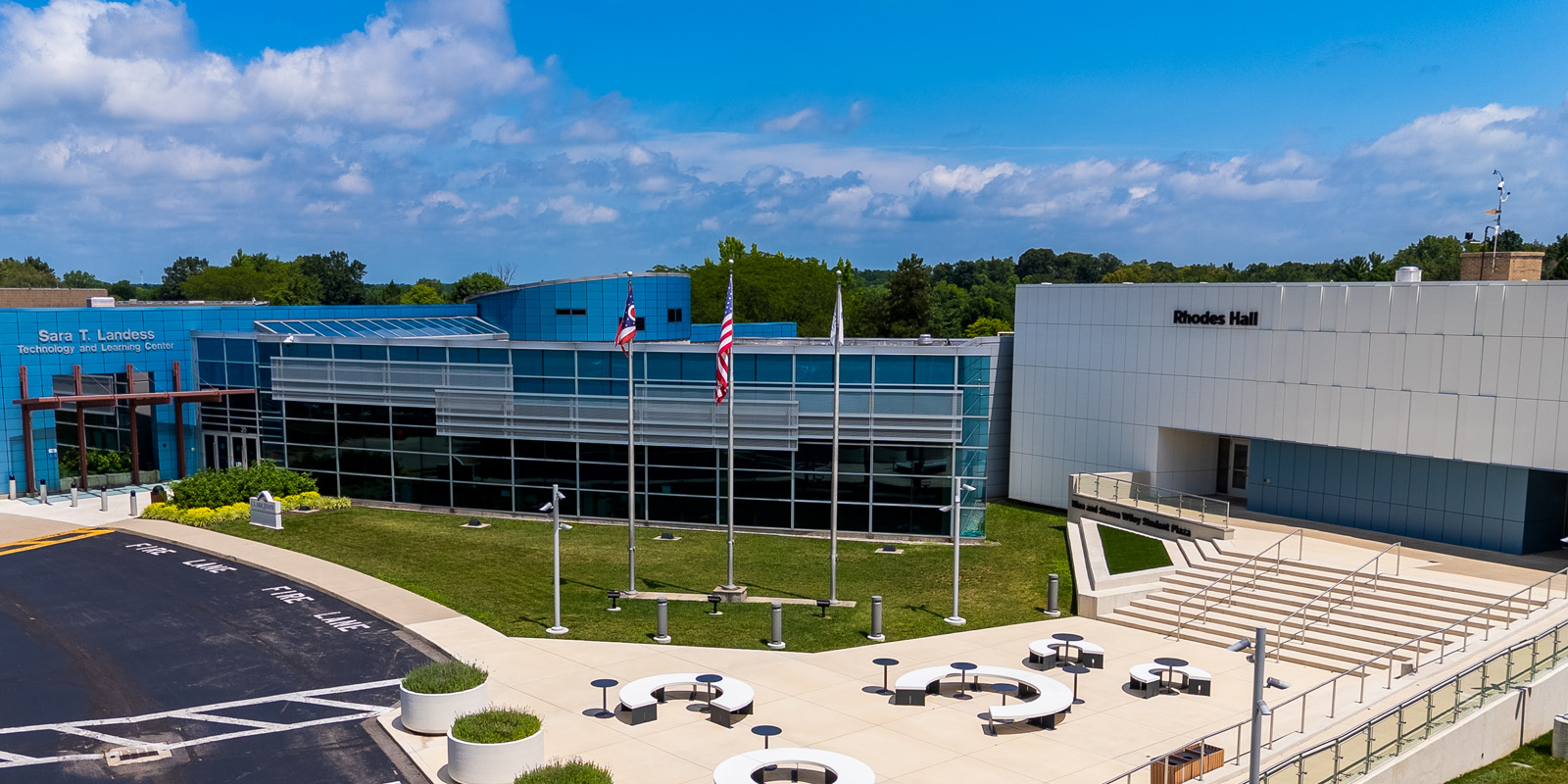 Exterior photo of the TLC building, which is blue, and Rhodes Hall, which is white.