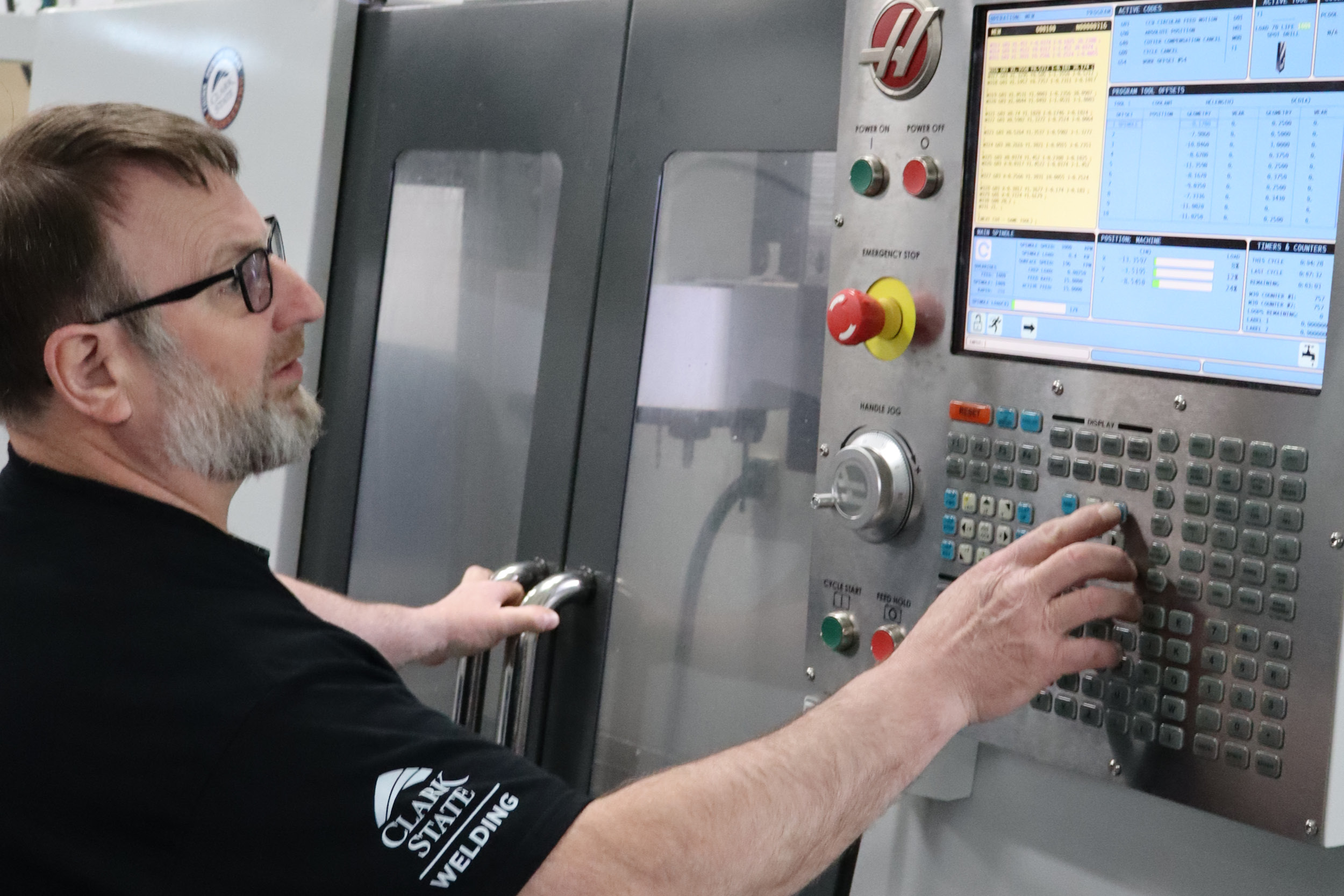 Man works on CNC equipment