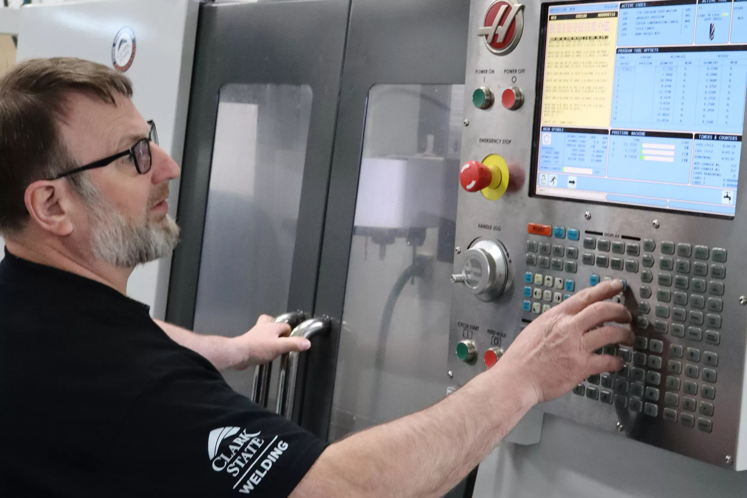 Man works on CNC equipment