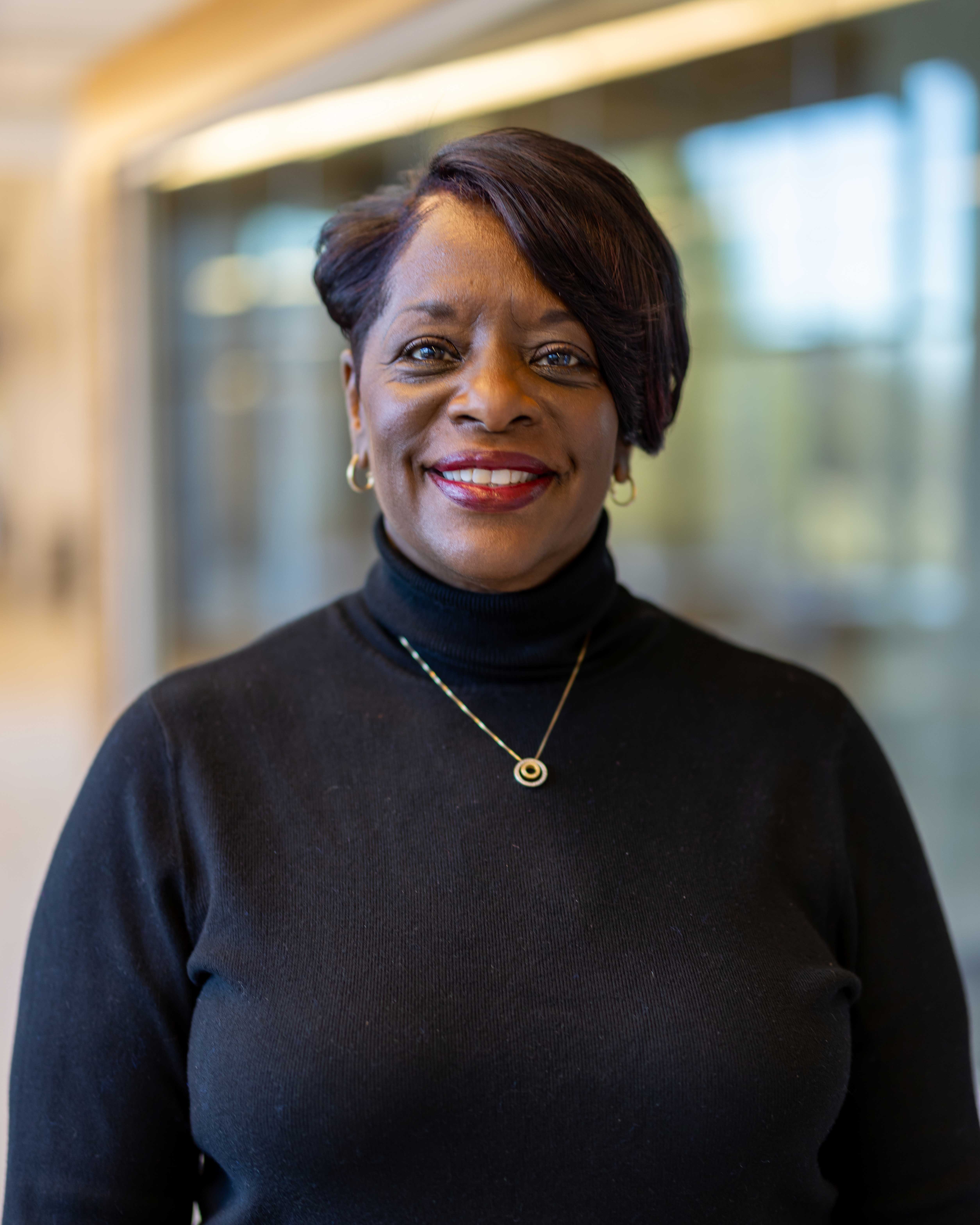 Sharon M. Evans wearing black turtleneck and gold necklace.