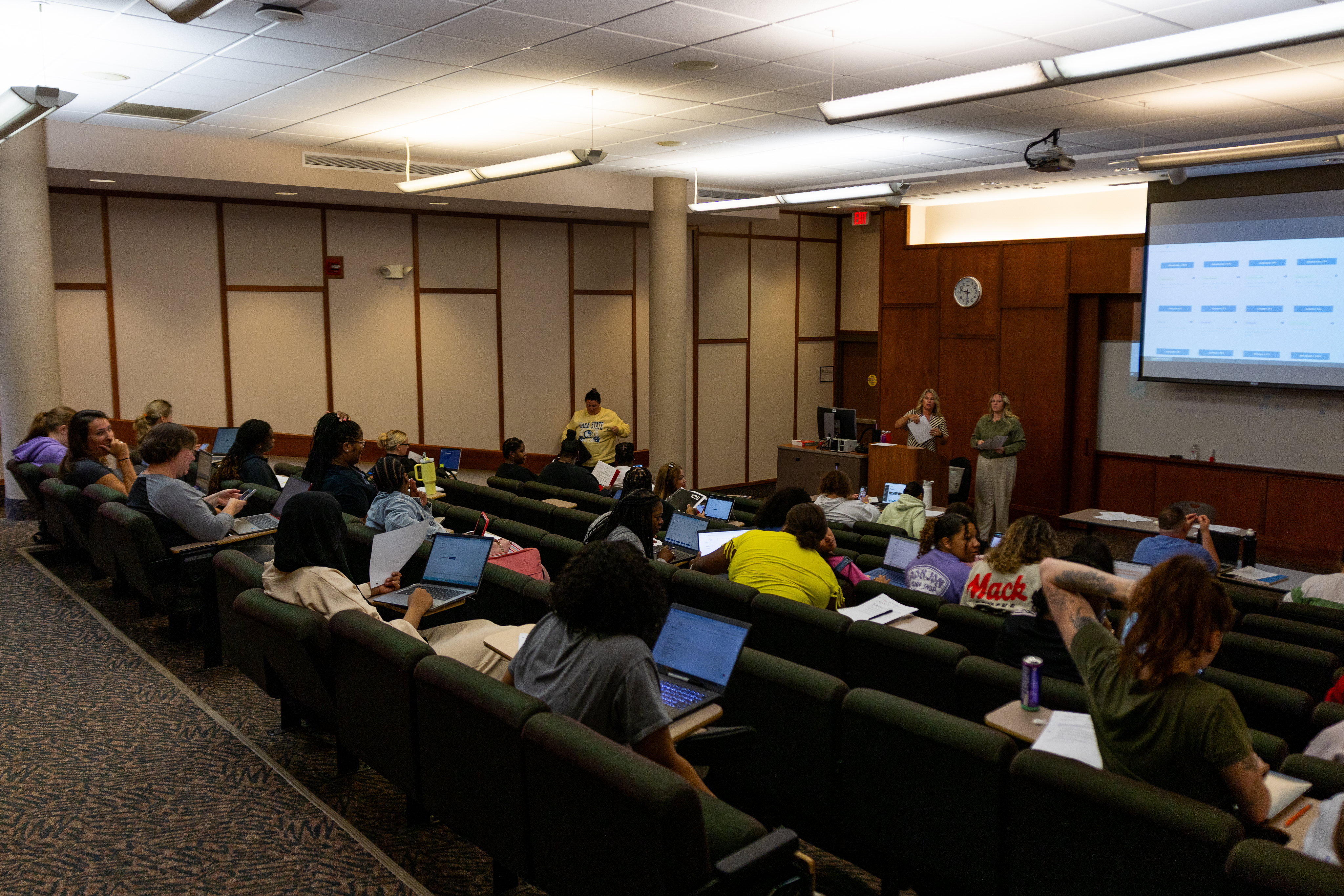 Students in a classroom listening to the teacher