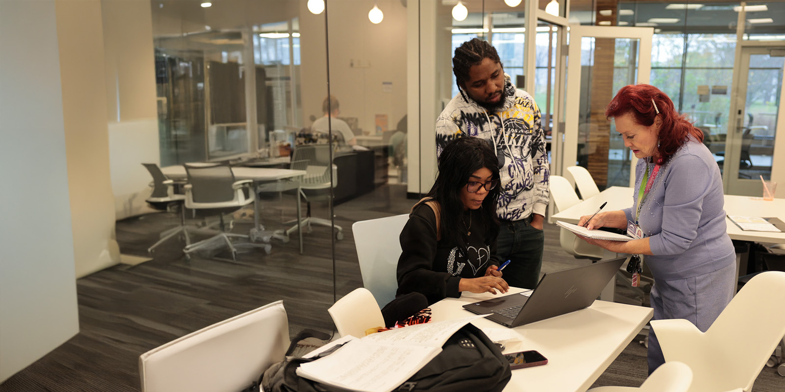 Students working with accessibility team member