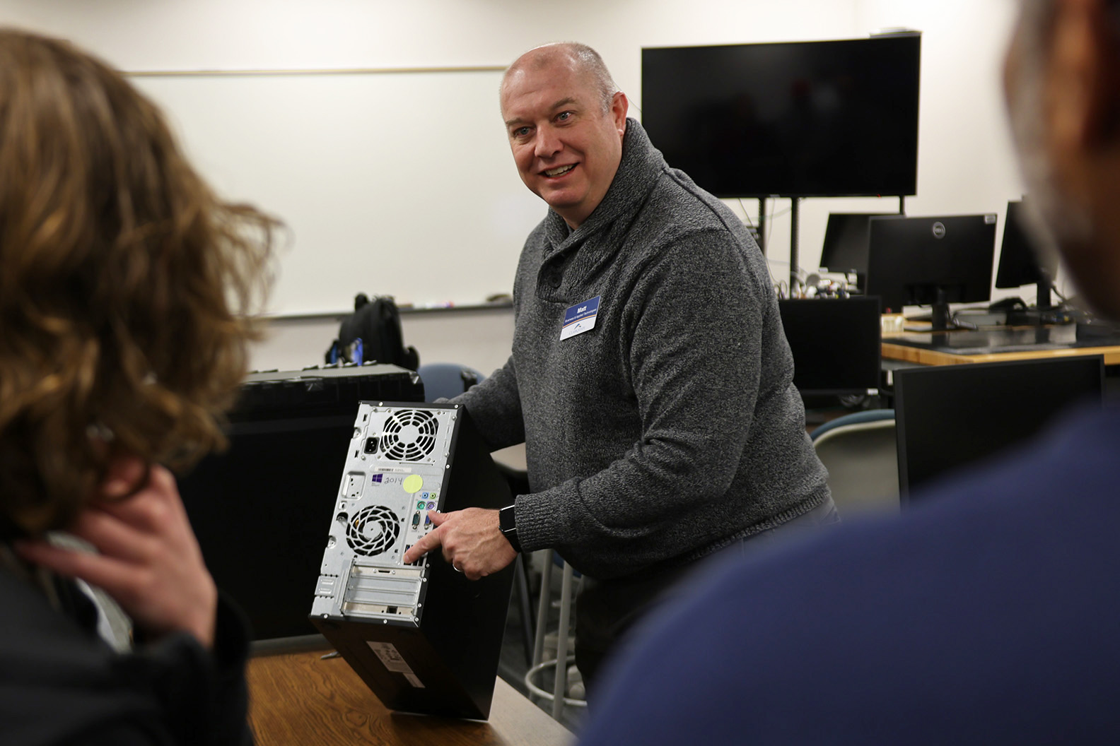 Faculty presenting on malware to students in a classroom.