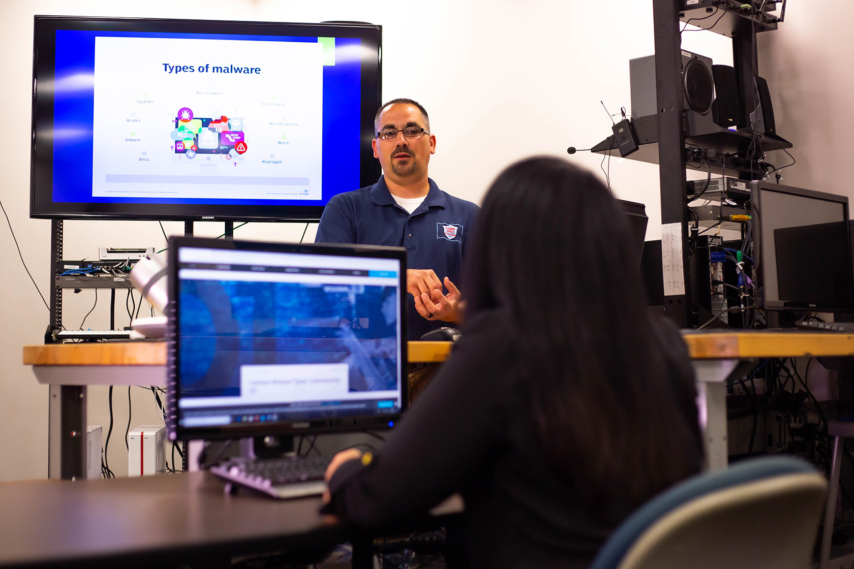 Faculty presenting on malware to students in a classroom.