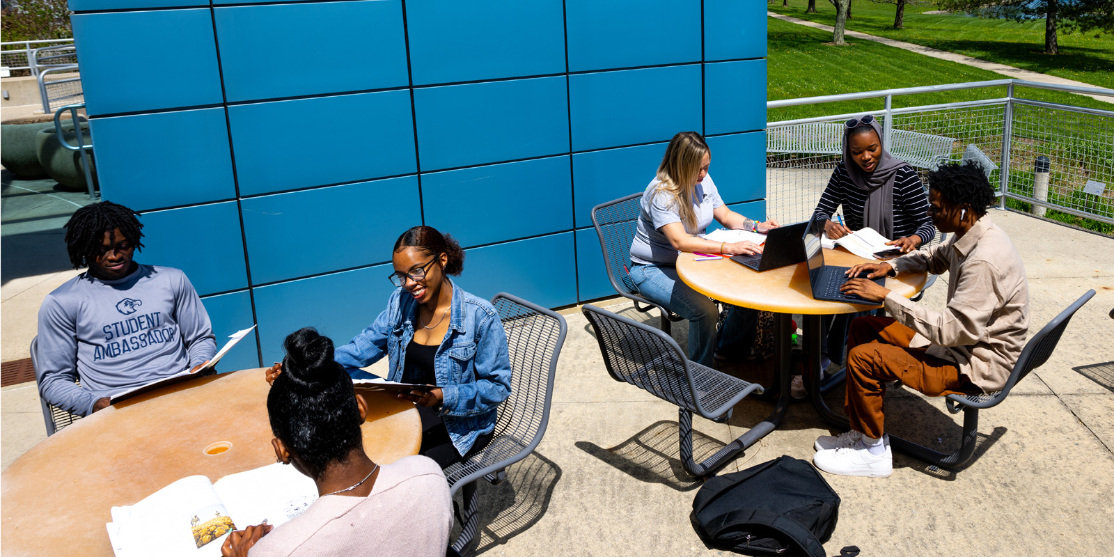 Students sitting at tables outside