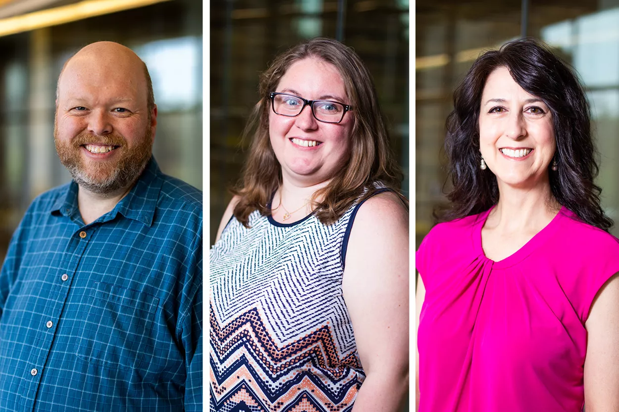 Three people. Left: Man in blue shirt. Middle: Woman with brown hair/glasses. Right: Woman with black hair/pink shirt