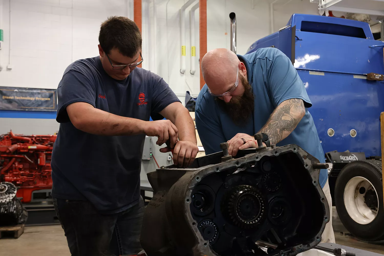 Two men work on a diesel engine in the diesel lab at Clark State.