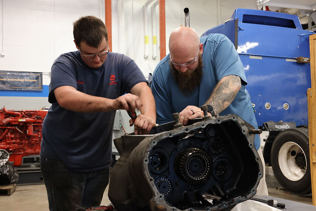 Student and teacher working on diesel engine