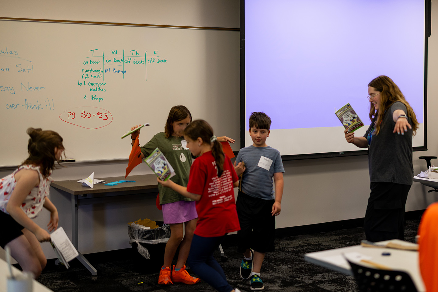 Teacher reading a book to a classroom of children.