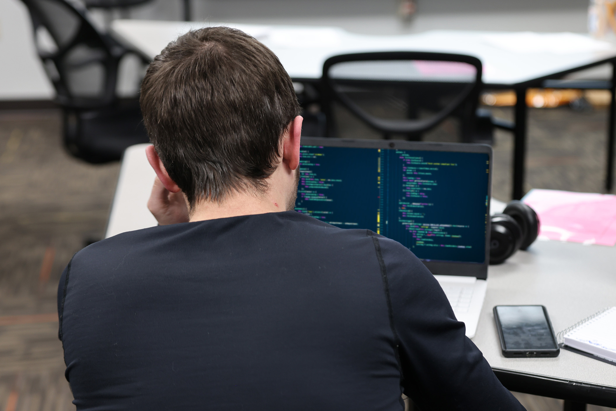 Student works at laptop on software coding