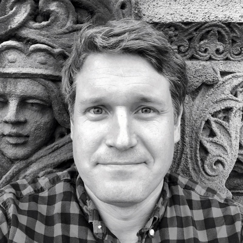 black and white photo of man again stone wall