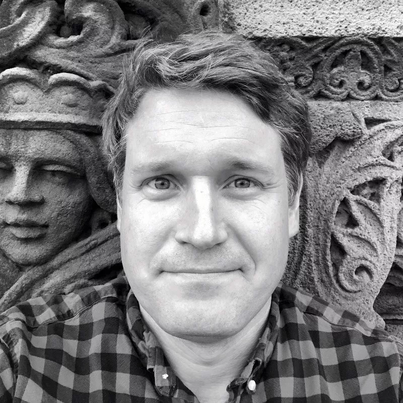 black and white photo of man again stone wall