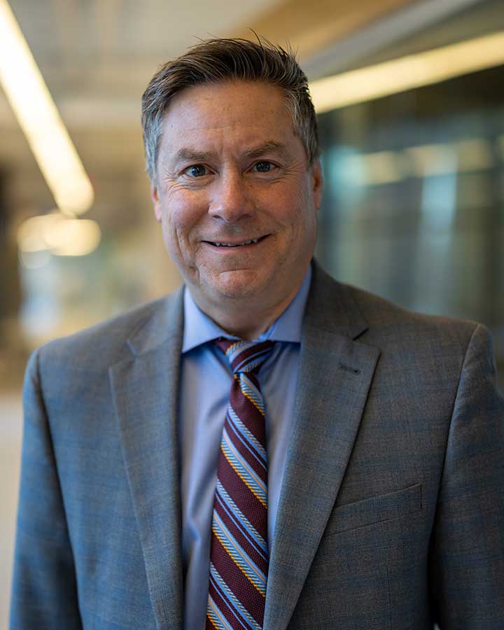 Mike McDorman wearing suite with a multicolored stripe tie.