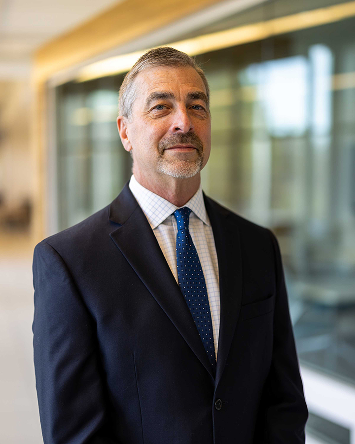 David Ball wearing a suite with a navy polka dot tie.