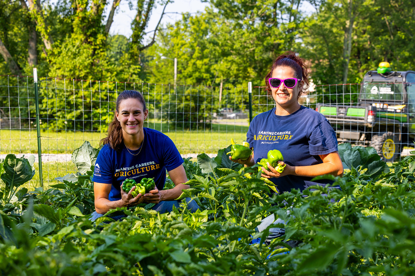 Students in garden holding vegetables