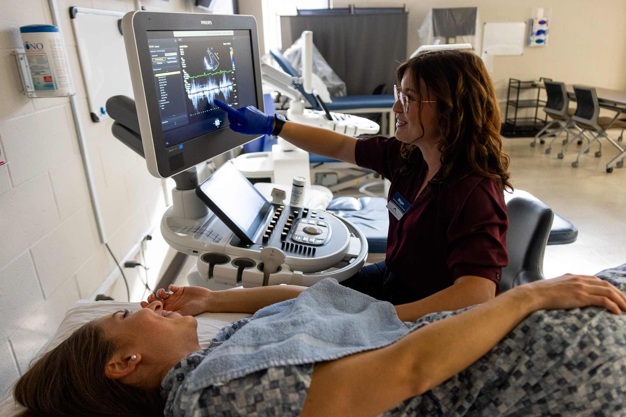 Two women review an echocardiogram on a screen showing ultrasound images of the heart.