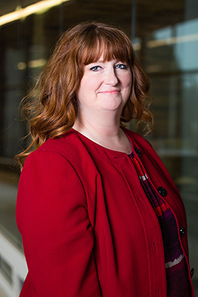 Melinda Mohler wearing red shirt and red cardigan smiling.