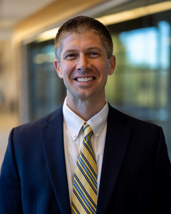 Ben Vollrath wearing suite with a yellow tie.